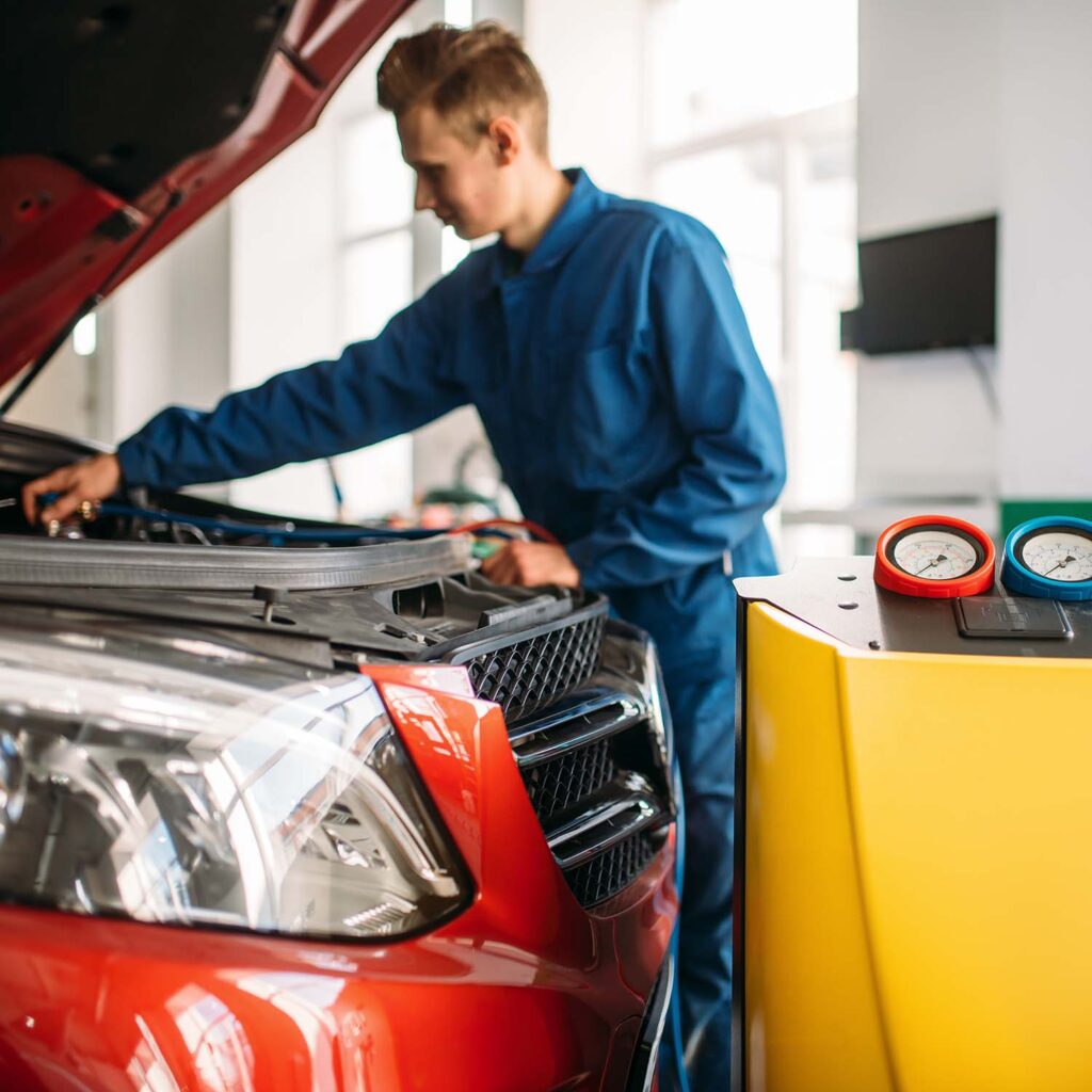 Mechanic checks air conditioning system in car